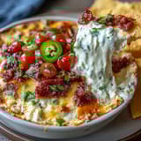Cinco de Mayo Loaded Queso Dip with chorizo and melted cheese in a skillet, topped with pico de gallo and jalapeños.