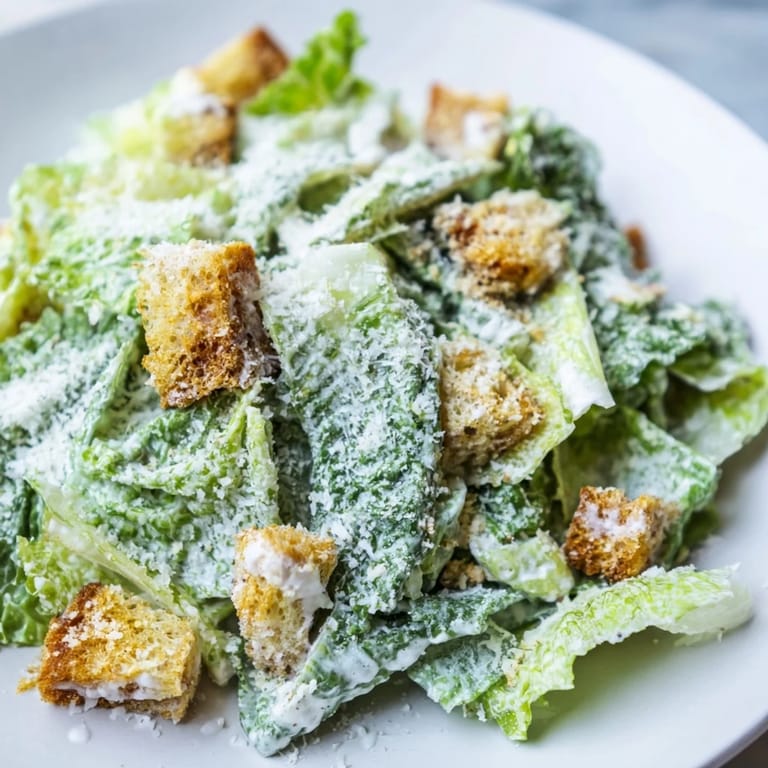 A vibrant photo of Caesar salad shows crunchy croutons and a tangy, delicious dressing that coats everything.