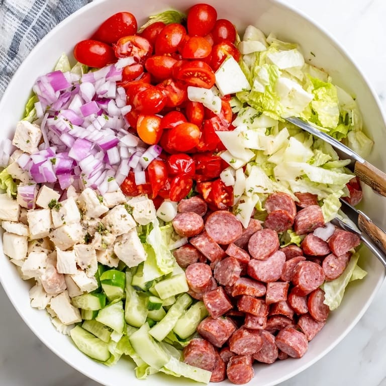 A close-up of Italian Deli Chopped Chicken Salad with chopped salami, provolone, and pepperoncini tossed in herb dressing.