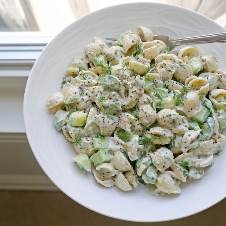 Close-up of chilled Cucumber Crunch Pasta Salad featuring diced cucumbers and green onions tossed in a tangy, creamy dressing.  