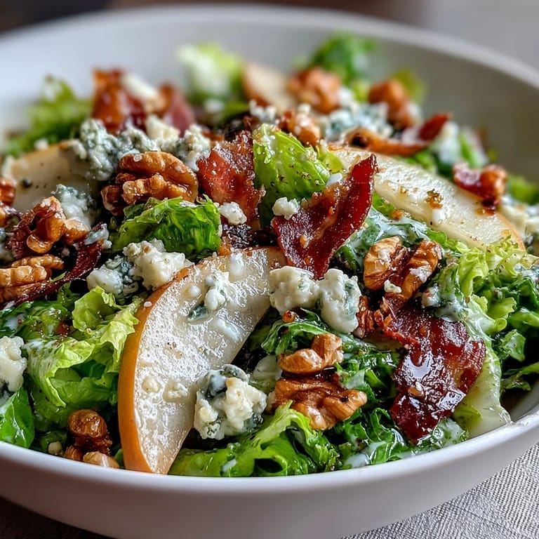 Vibrant Frisée, Pear, Blue Cheese, and Crispy Prosciutto Salad on a rustic plate, featuring juicy pear slices, creamy blue cheese crumbles, and crisp prosciutto over delicate frisée.  