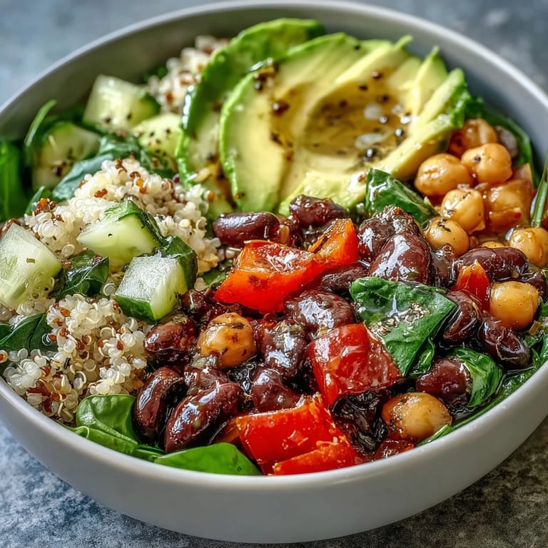 Colorful Three-Bean Power Bowl featuring cherry tomatoes, cucumber, and fresh cilantro garnish, served in a white bowl.