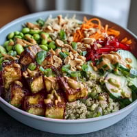 1. Vibrant peanut tofu power bowl with crispy tofu, colorful veggies, and creamy peanut sauce for a nourishing meal.  