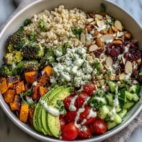 A vibrant customizable grain bowl with brown rice, grilled chicken, roasted sweet potato, and fresh vegetables, drizzled with lemon-tahini dressing.  